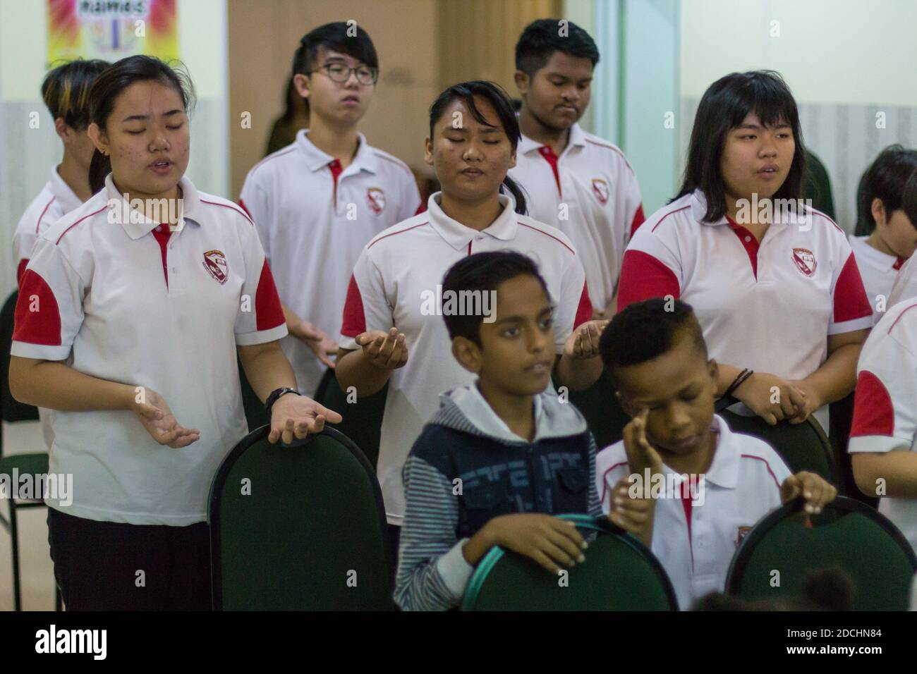 Schulkinder beten und beten vor dem Unterricht. Stockfoto