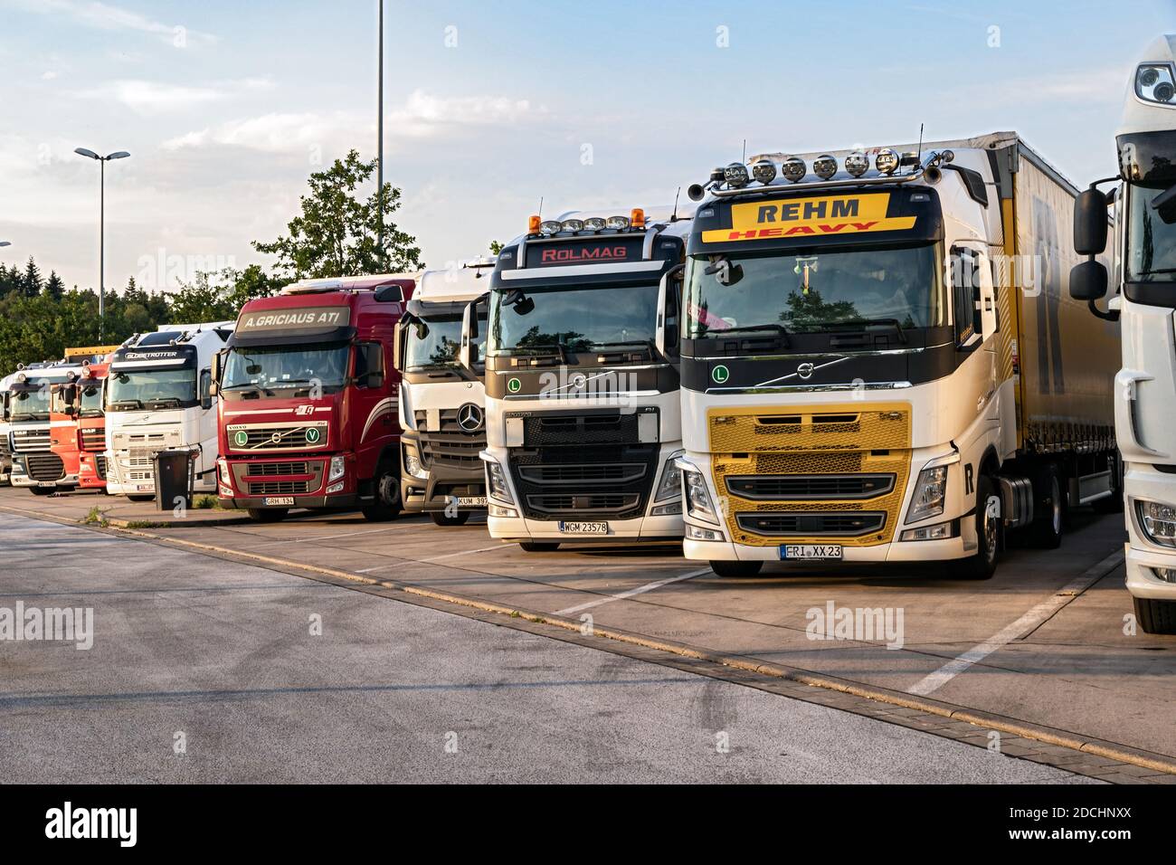 Reihe von verschiedenen Firmen-Lkw auf einem LKW-Parkplatz über Nacht somwehere entlang der Autobahn E30 geparkt. Deutschland - 14. Juni 2019 Stockfoto