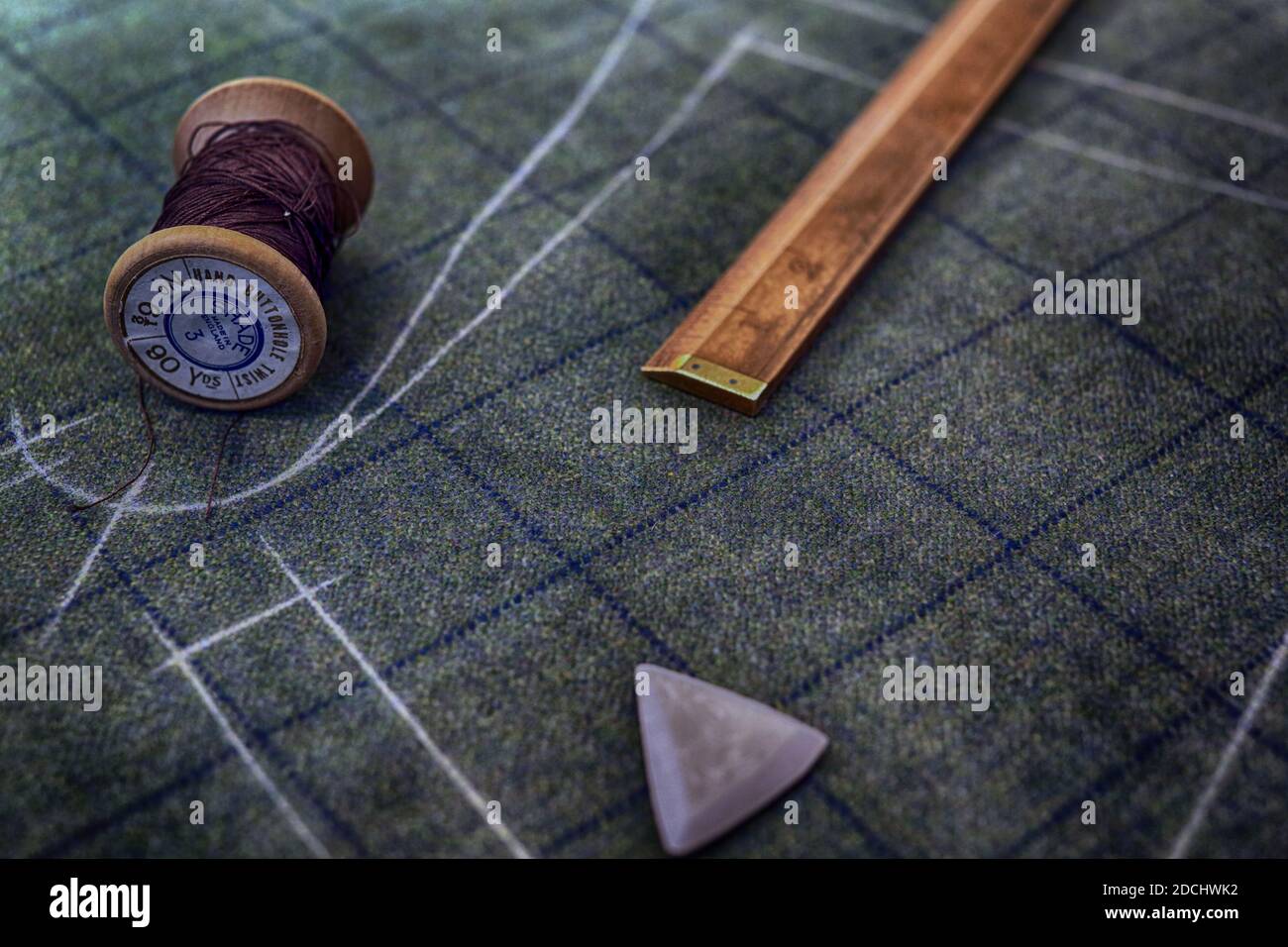 Fäden und Holzkalen auf Stoff markiert in Kreide mit dem Muster des Kleidungsstücks aus nächster Nähe, Huntsman, Savile Row. Stockfoto
