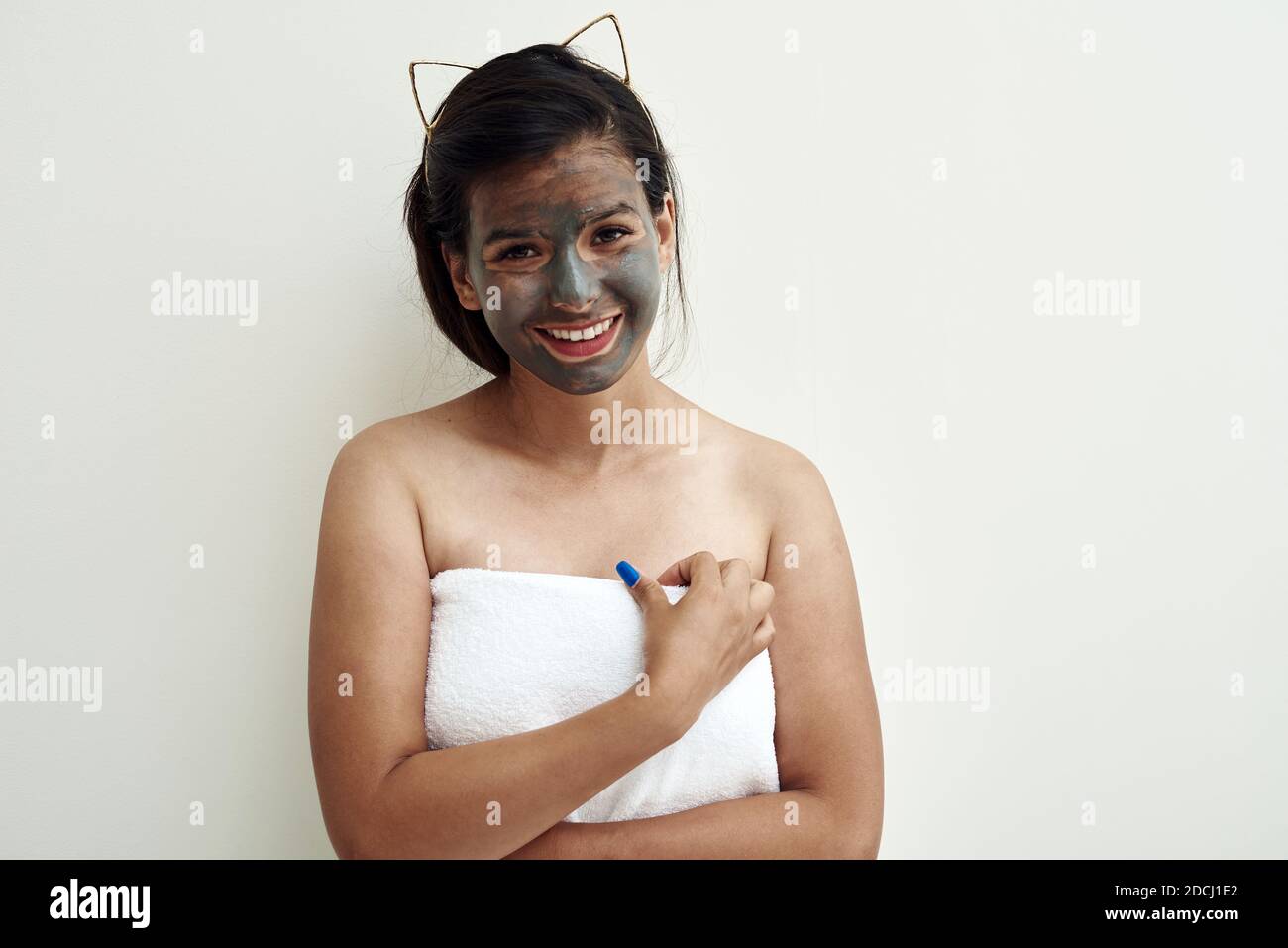 Spa Schönheitsbehandlung, Hautpflege. Junge Frau, die Gesichtsmaske aus grauem Lehm auf ihr Gesicht anwendet. Stockfoto