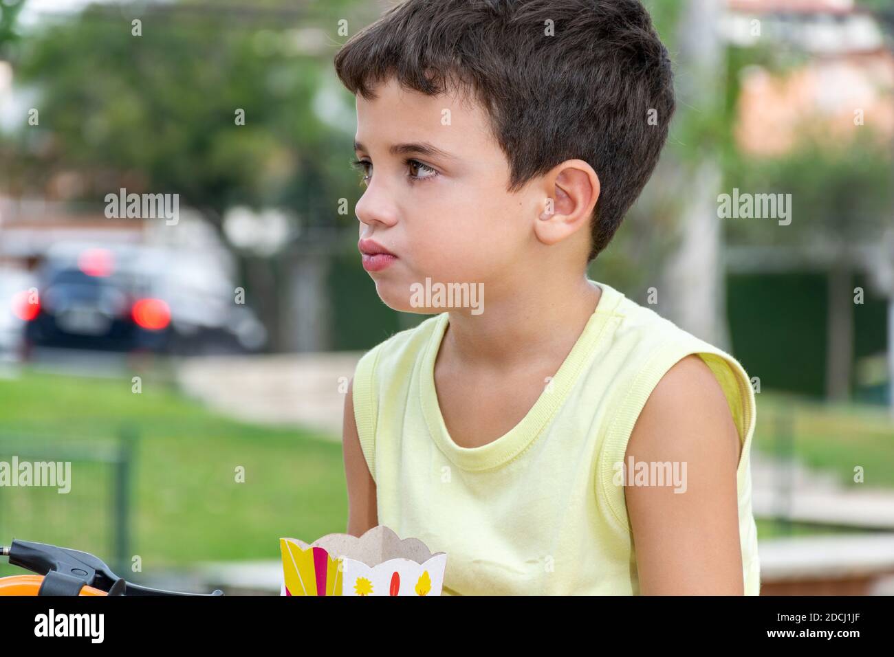 6 Jahre altes Kind am Nachmittag auf dem Honório Sabino Platz, das Fahrrad spielt, mit Hunden und Popcorn isst. Stockfoto