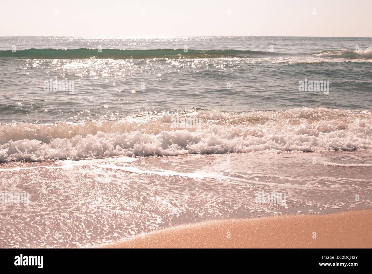 Meer mit hellen Wellen, die Sonne funkelt im Wasser. Reisen und Tourismus, Erholung und Entspannung. Stockfoto