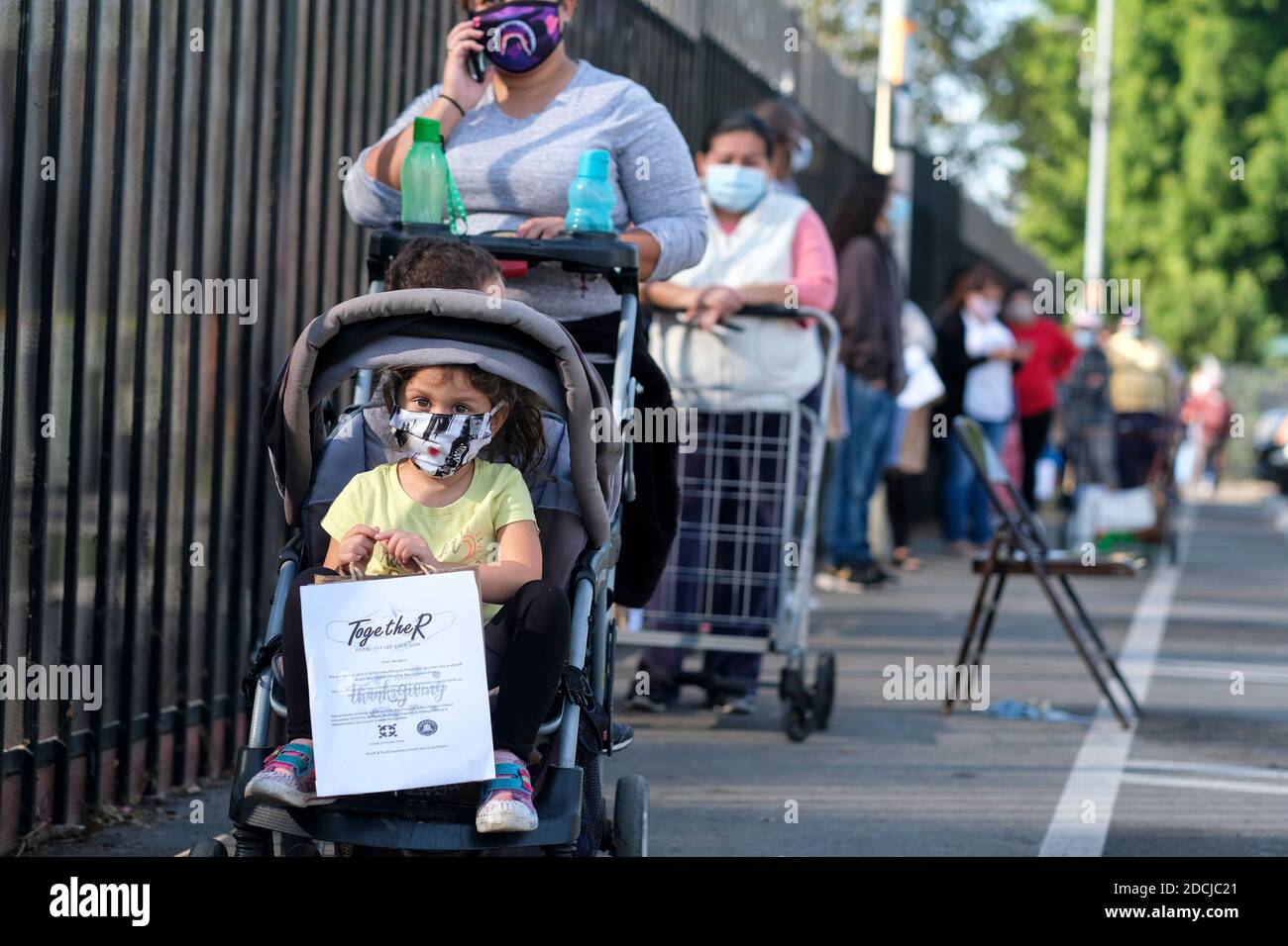 Los Angeles, Kalifornien, USA. November 2020. Während einer Lebensmittelverteilung in Los Angeles am Samstag, den 21. November 2020, warten Menschen in der Schlange auf Nahrung. Die Verteilung bietet Hunderte von kostenlosen, nahrhaften Mahlzeiten für bedürftige Gemeindemitglieder und wird Teil eines größeren Programms sein, das im November und Dezember 6,000 kostenlose Mahlzeiten für die Bewohner von Black, die überproportional von der Coronavirus-Pandemie betroffen sind, serviert. Kredit: Ringo Chiu/ZUMA Wire/Alamy Live Nachrichten Stockfoto