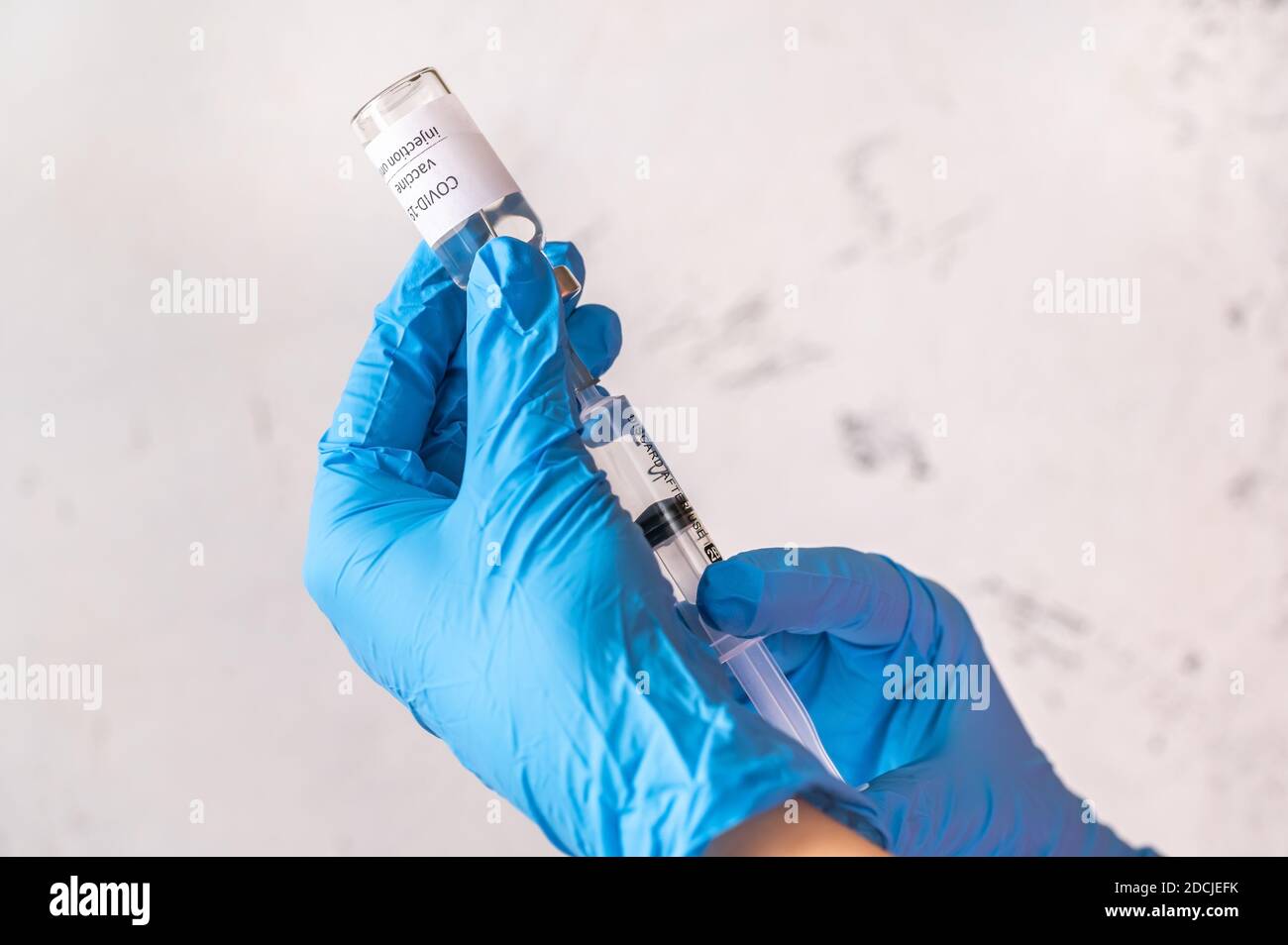 Arzt, der Medikamente aus Coronavirus-Impfstoffröhrchen abzieht Stockfoto