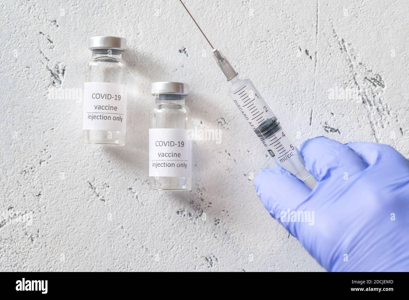 Arzt, der Medikamente aus Coronavirus-Impfstoffröhrchen abzieht Stockfoto