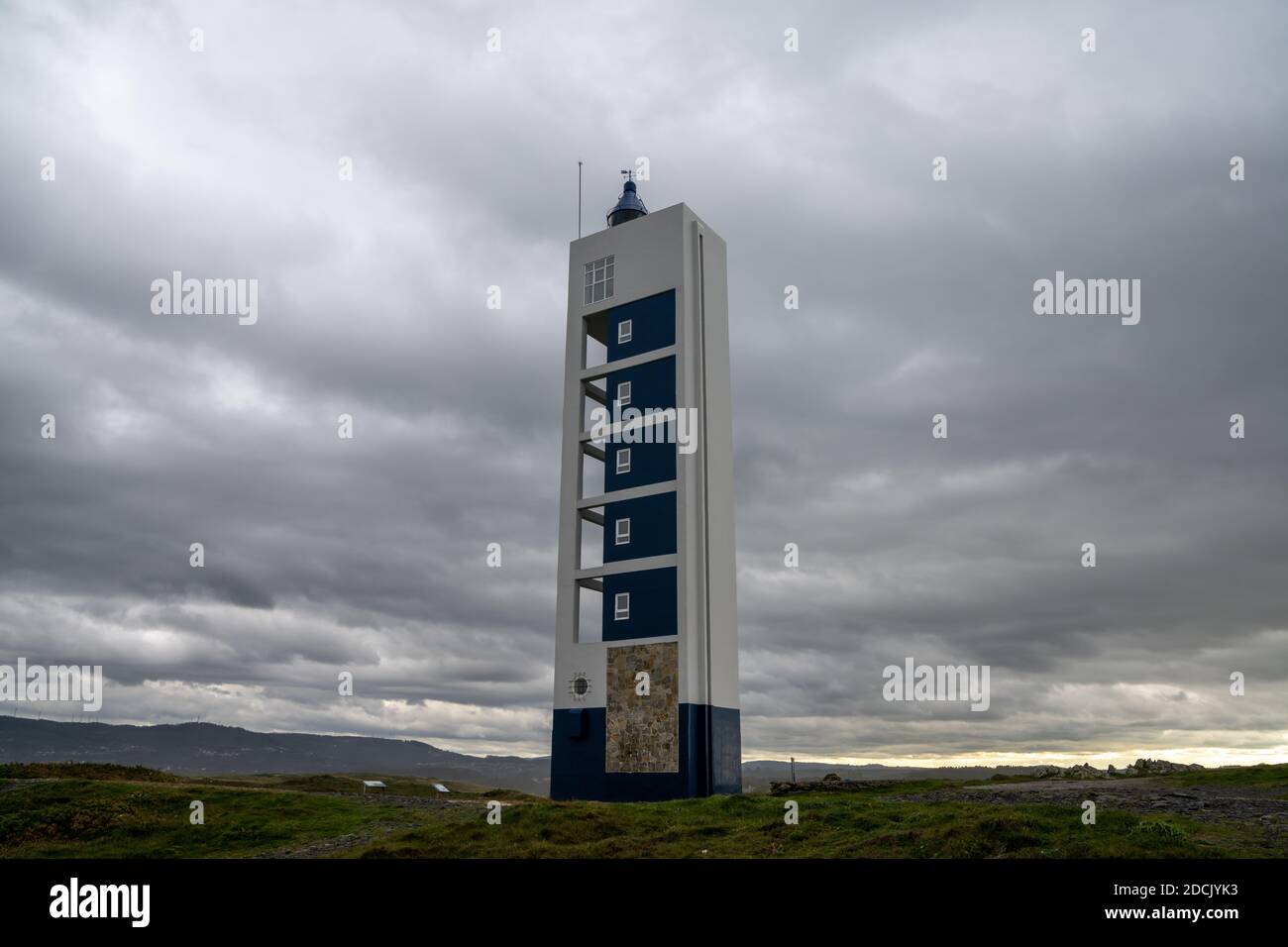 Der moderne Leuchtturm Punta Frouxeira unter einer grauen stürmischen Bewölkt Himmel Stockfoto