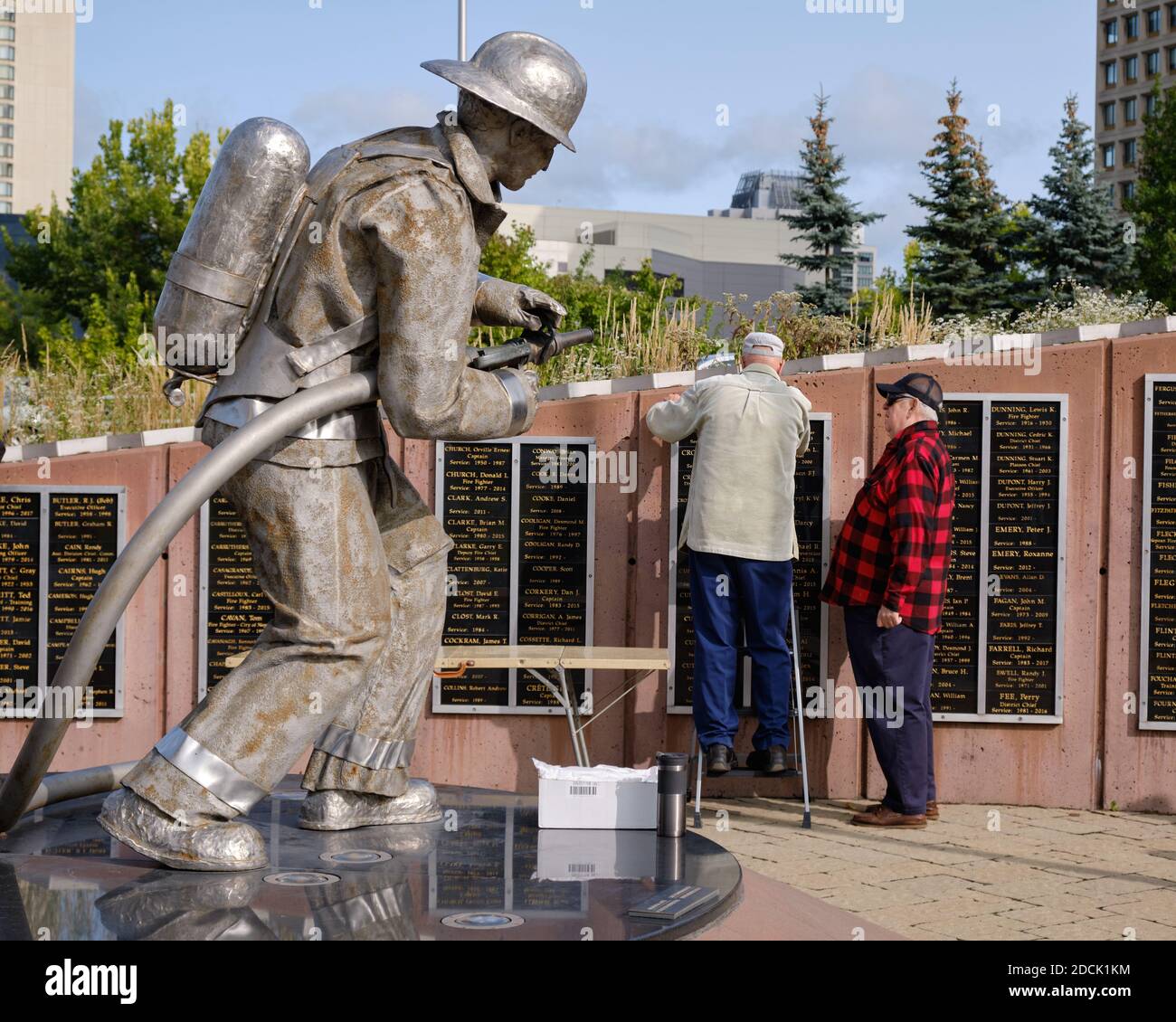 Freiwillige Aktualisierung Plaketten auf Ottawa Firefighter Memorial , in Ottawa Kanada. Suchen wie Statue ist sie zu schmieren Stockfoto