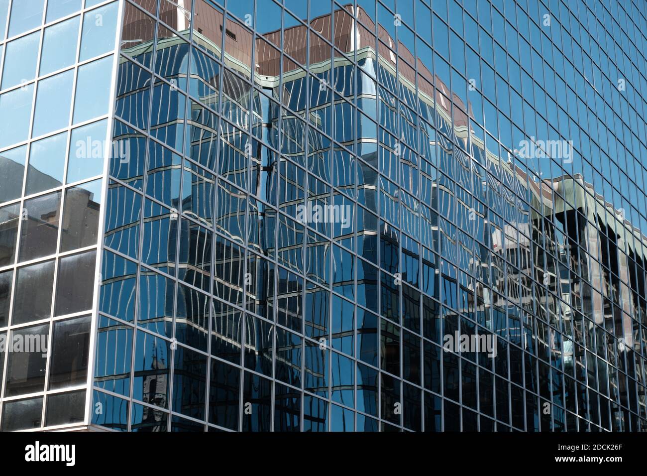 Gebäudehautreflektionen auf einem Gebäude aus quadratischen Fensterscheiben Wie Spiegel Stockfoto