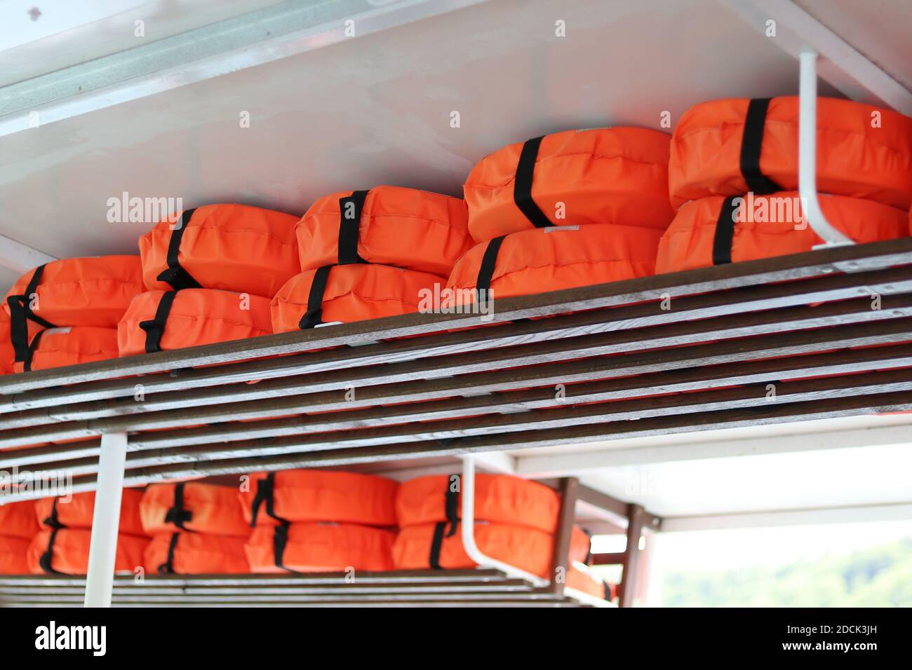 Ansicht der gestapelten orange Schwimmwesten auf weißem Hintergrund Stockfoto