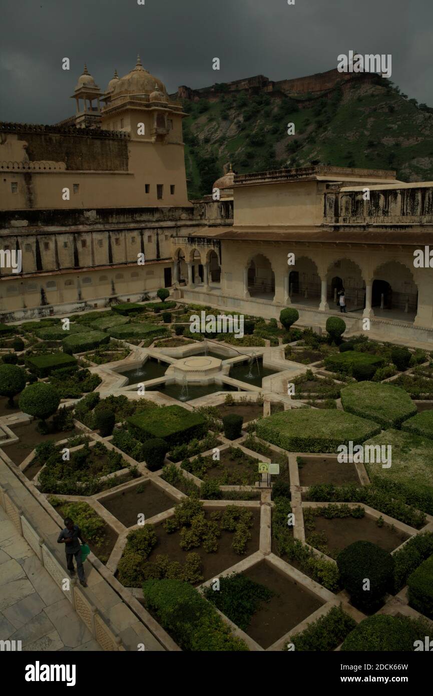 Garten in Amer Fort Komplex mit einem Teil der Jaigarh Fort auf Cheel ka Teela (Berg der Adler) befindet, kann in der Ferne gesehen werden. Rajasthan, Indien. Stockfoto
