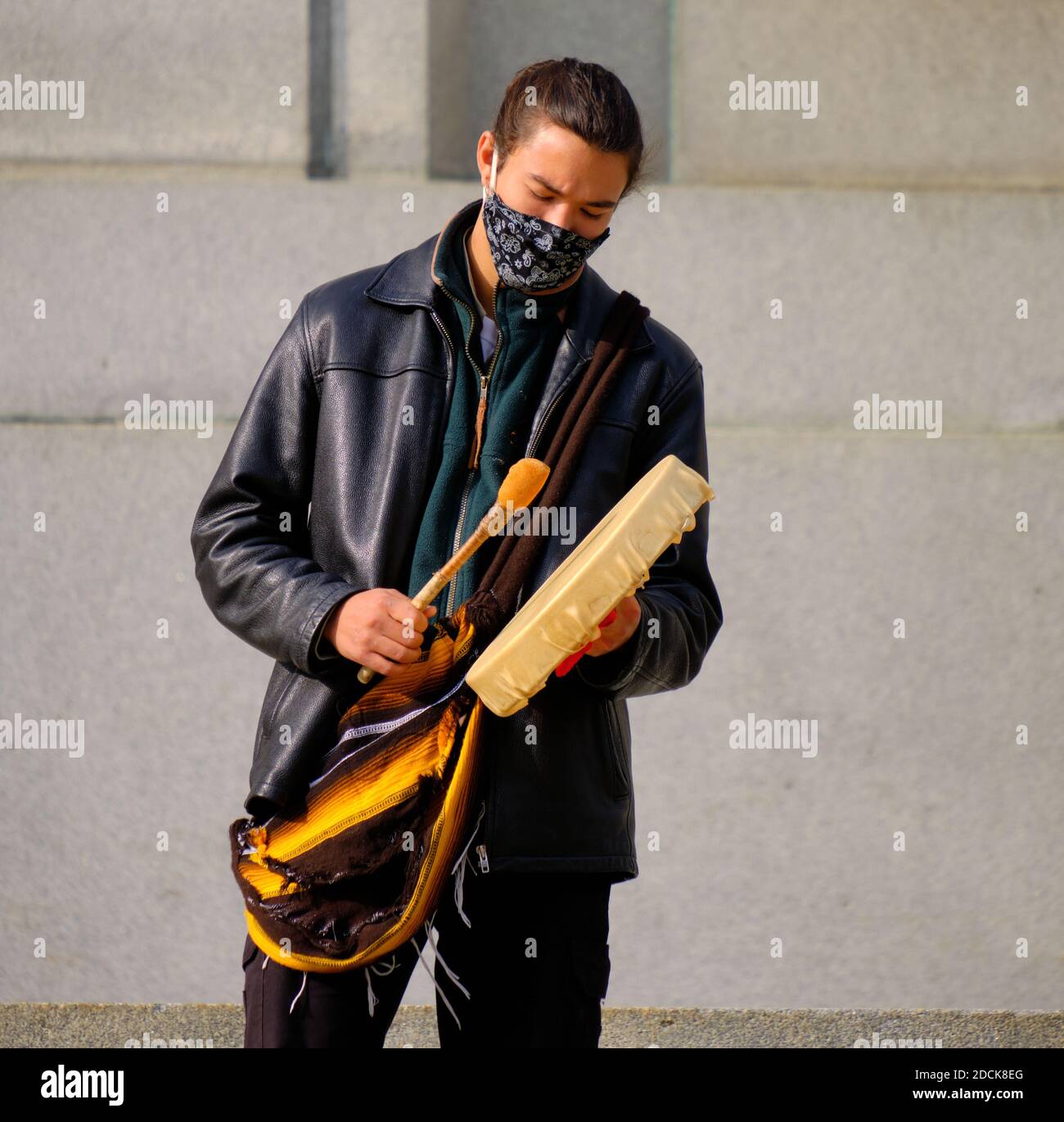 First Nation junger Mann mit Gesichtsmaske und traditioneller Trommel bei einem Protest in Ottawa, Kanada Stockfoto