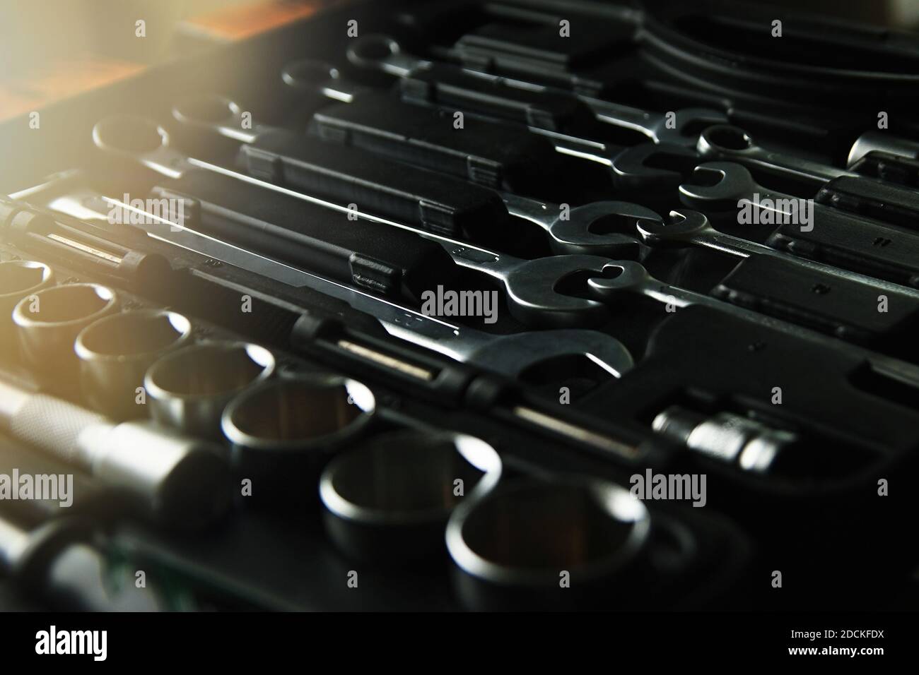 Box mit Werkzeugsatz für Autoreparatur, Nahaufnahme, Low-Key mit Lens Blendung Stockfoto