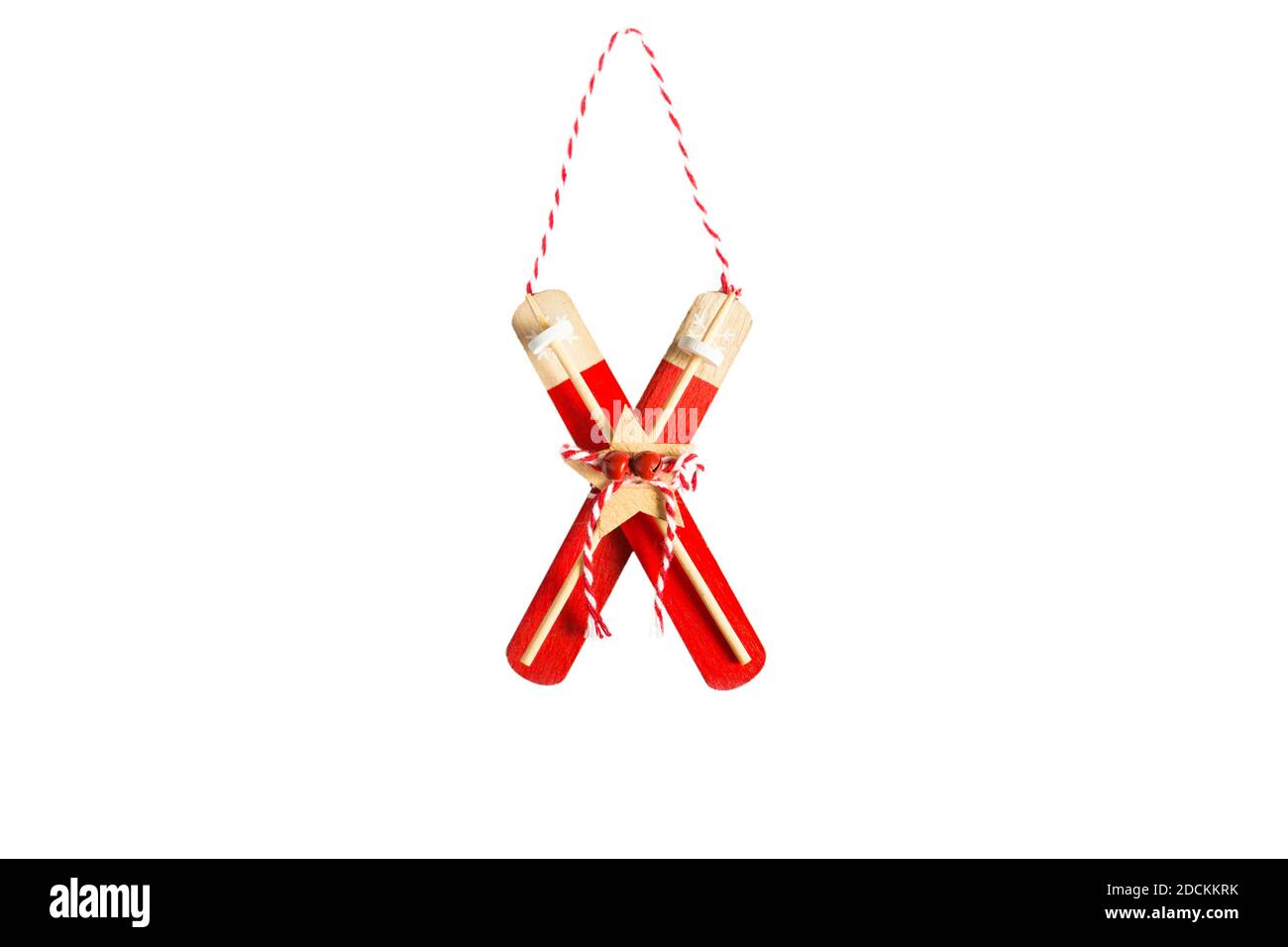 Rote Weihnachtsbaum Spielzeug-Holzskier mit Stöcken, Glocken und gestreiftem Seil auf weißem Hintergrund, isolieren. Neujahr, Weihnachten, Dekor zum Thema Wint Stockfoto