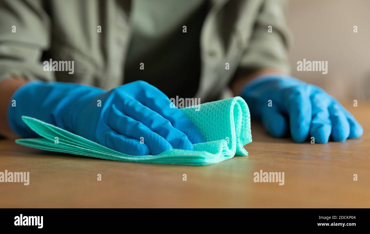 Ernte der Frau in Gummihandschuhen Reinigung Holzoberfläche Stockfoto