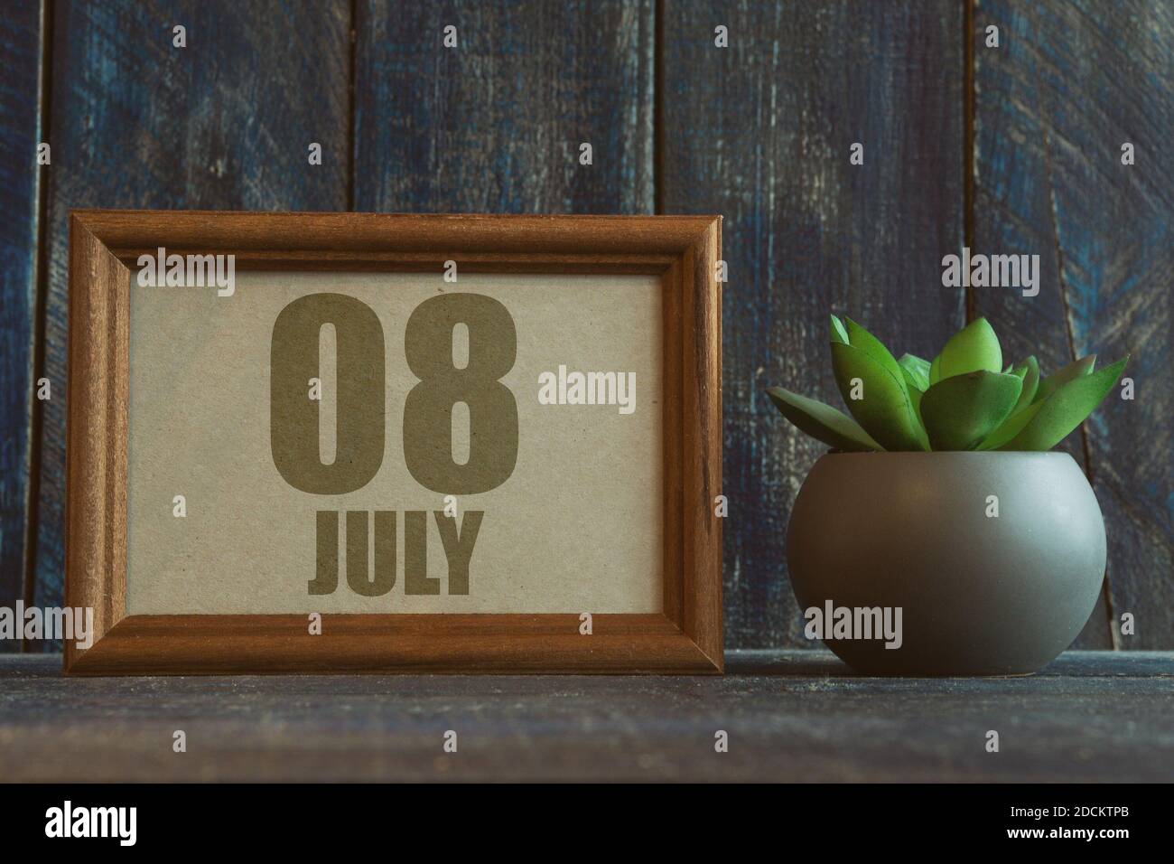 juli. Tag 8 des Monats, Datum im Rahmen neben Sukkulenten auf hölzernen Hintergrund Sommermonat, Tag des Jahres Konzept. Stockfoto