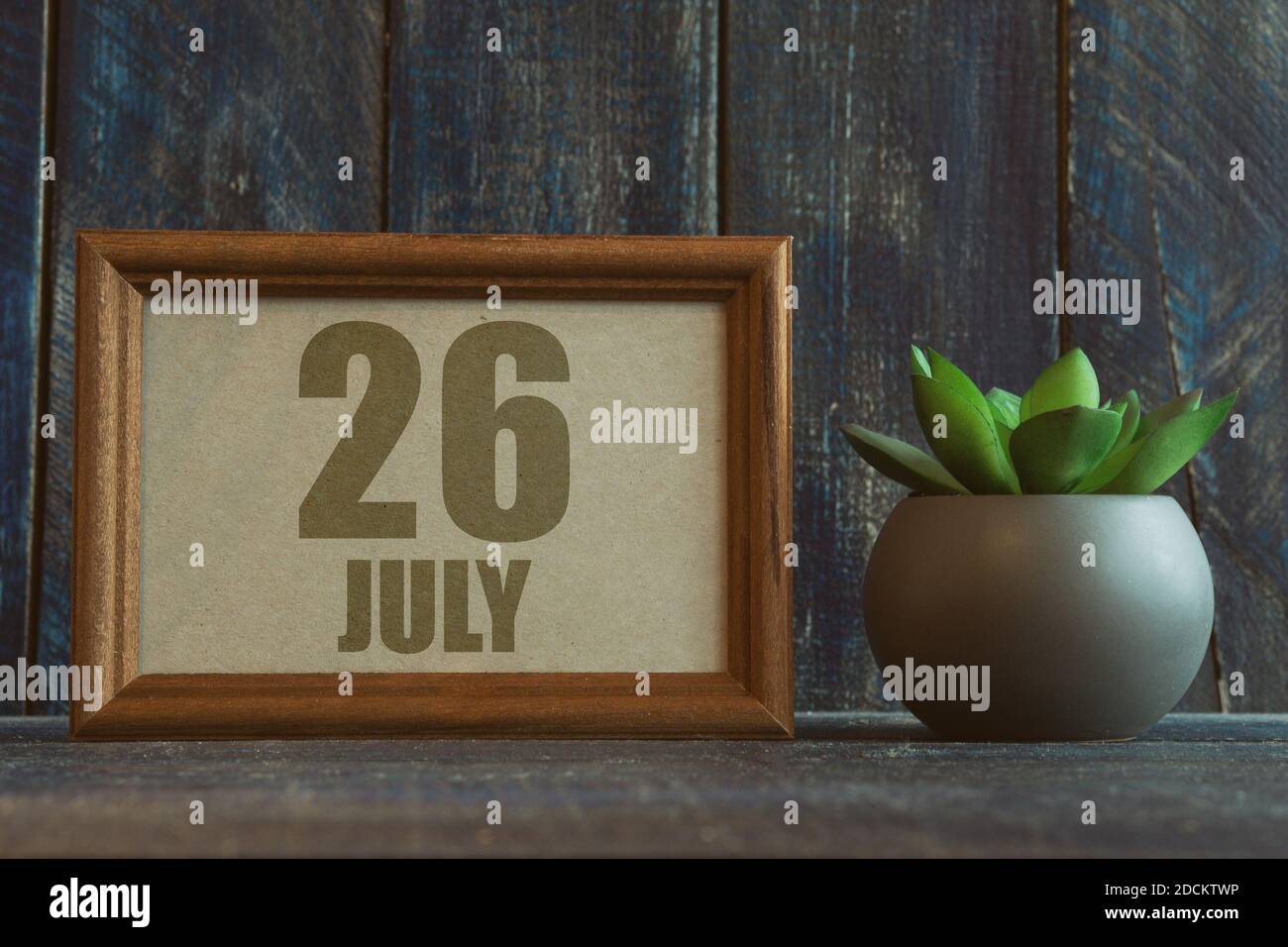 juli. Tag 26 des Monats, Datum im Rahmen neben Sukkulenten auf hölzernen Hintergrund Sommermonat, Tag des Jahres Konzept. Stockfoto