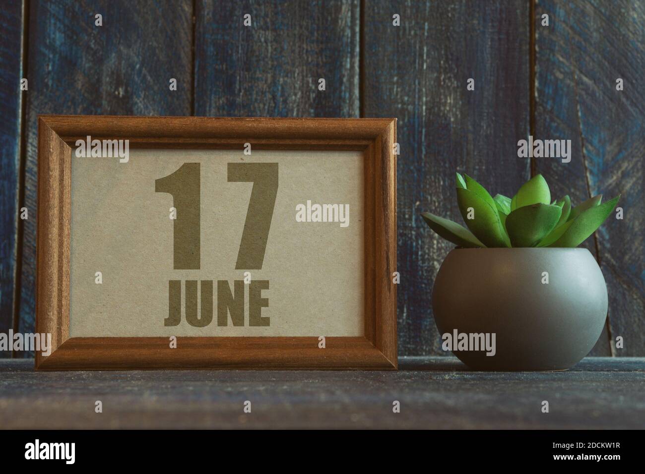 juni. Tag 17 des Monats, Datum im Rahmen neben Sukkulenten auf hölzernen Hintergrund Sommermonat, Tag des Jahres Konzept. Stockfoto