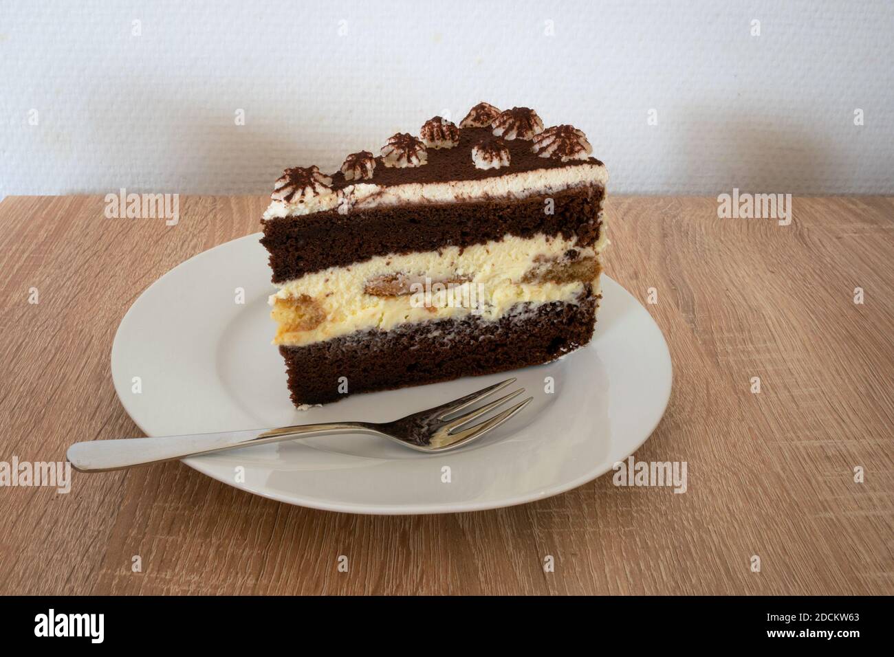 Scheibe Tiramisu-Kuchen mit Schlagsahne und Schokolade verziert Pulver Stockfoto