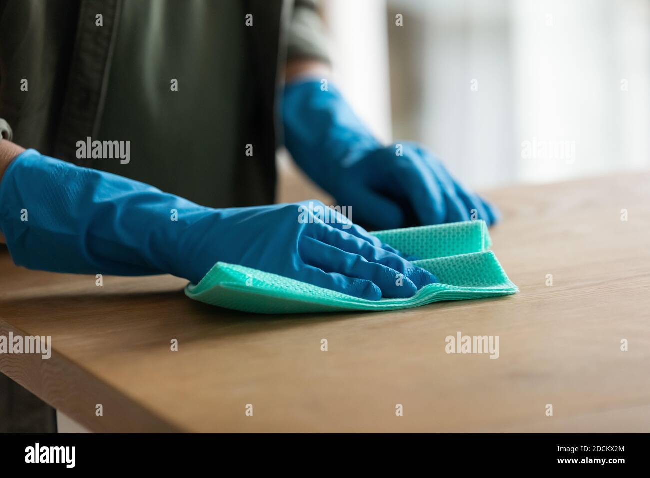 Nahaufnahme der Frau in Gummihandschuhen reinigen Holzoberfläche Stockfoto