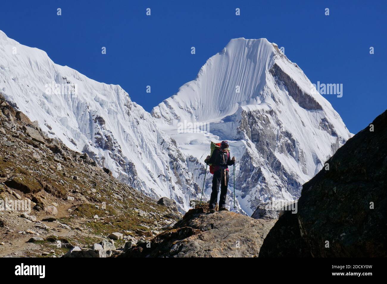 Müde Tourist Mädchen der chinesischen Etnität mit einem Stöcke für das Wandern auf dem Hintergrund der Himalaya-Berge während Trekking EBC (Everest Base Camp). Stockfoto