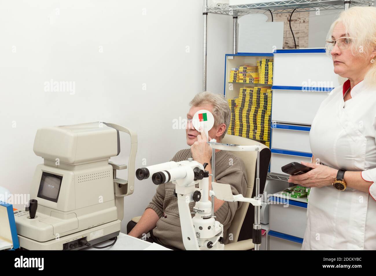 Der Mann überprüft sein Sehvermögen bei einem Termin mit einem Augenarzt in einer Arztpraxis. Arzt und Patient in einer Augenklinik. Sichtprüfung Stockfoto