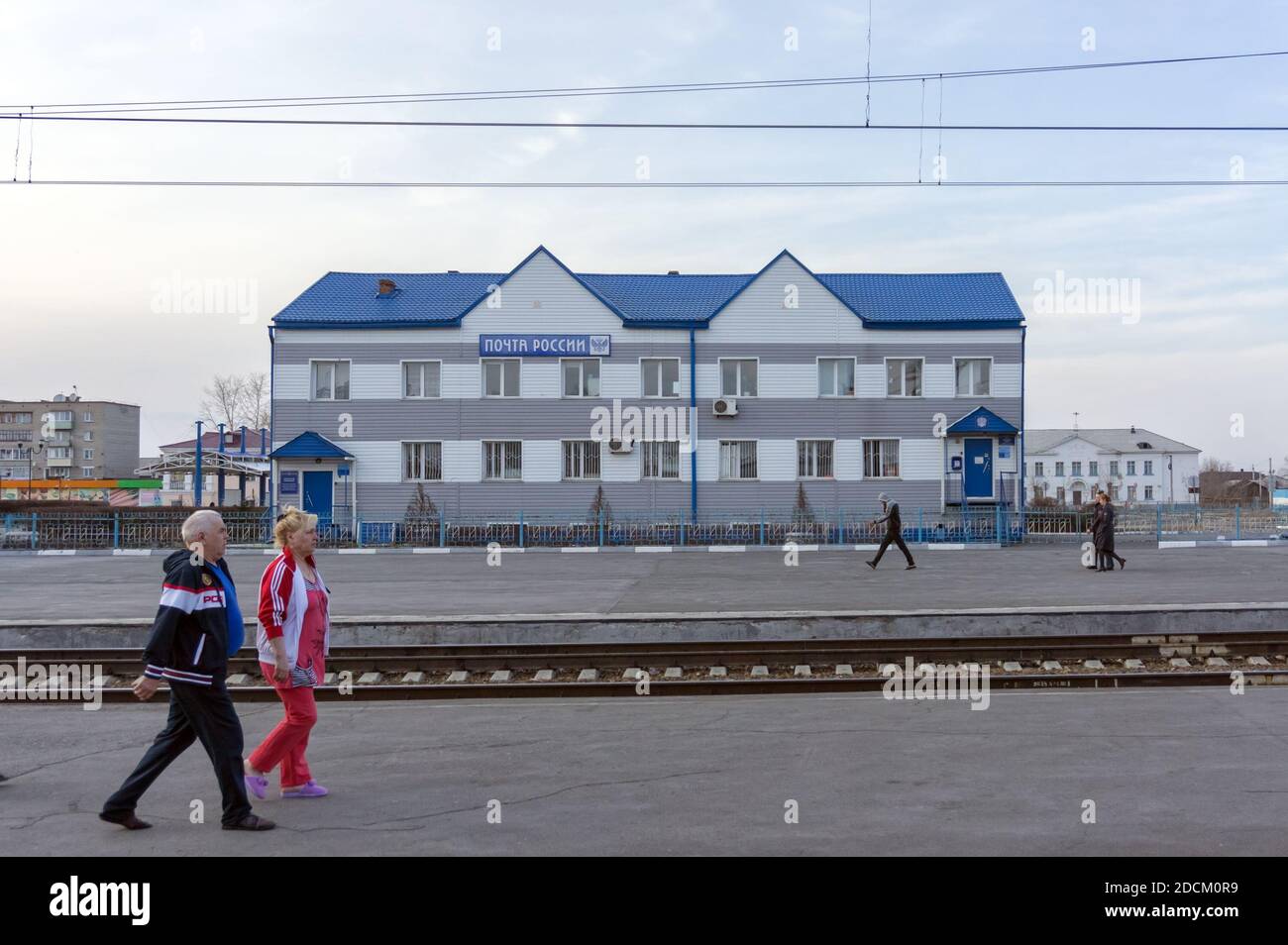 An einem Bahnhof in der sibirischen Stadt Barabinsk laufen die Menschen am Büro einer großen russischen Bundesgesellschaft Russian Post vorbei. Stockfoto
