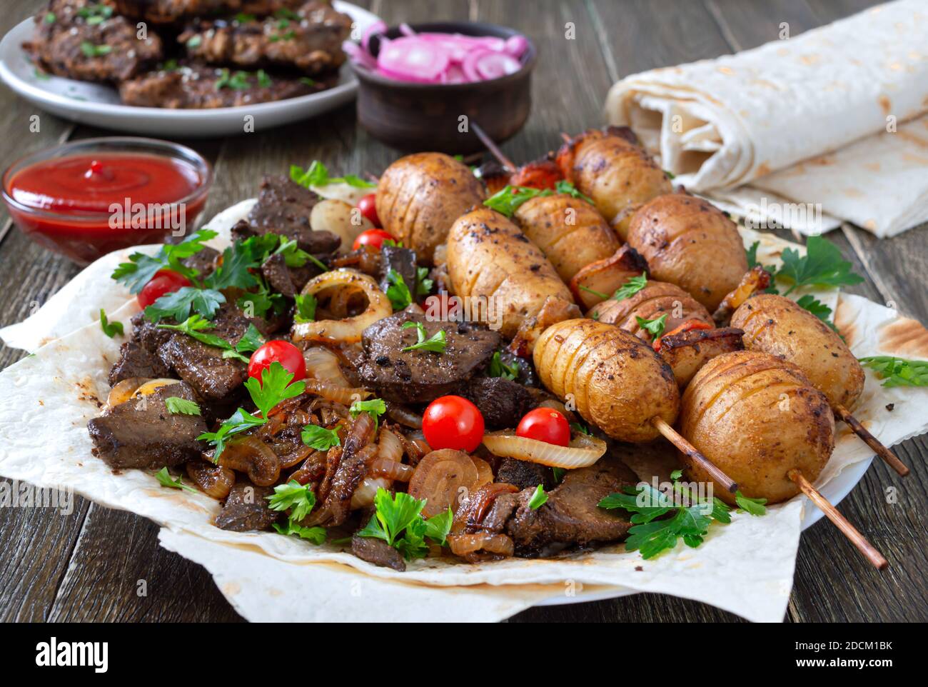 Gebratene Leber, Vollgemüse und Pilze auf Spieße mit Pita, Ketchup, eingelegten Gurken, roter Zwiebel. Speisekarte vom Grill-Restaurant. Georgische, asiatische Küche Stockfoto