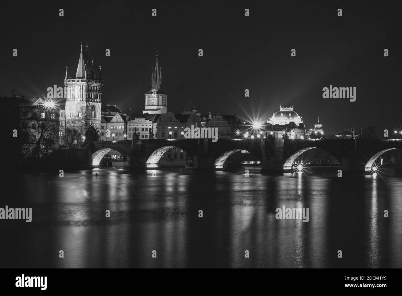 Abendpanorama von Prag, Tschechische Republik. Schwarzweiß-Foto. Karlsbrücke, Karluv spiegelt sich am meisten in der Moldau. Stadtlichter mit langer Belichtung Stockfoto
