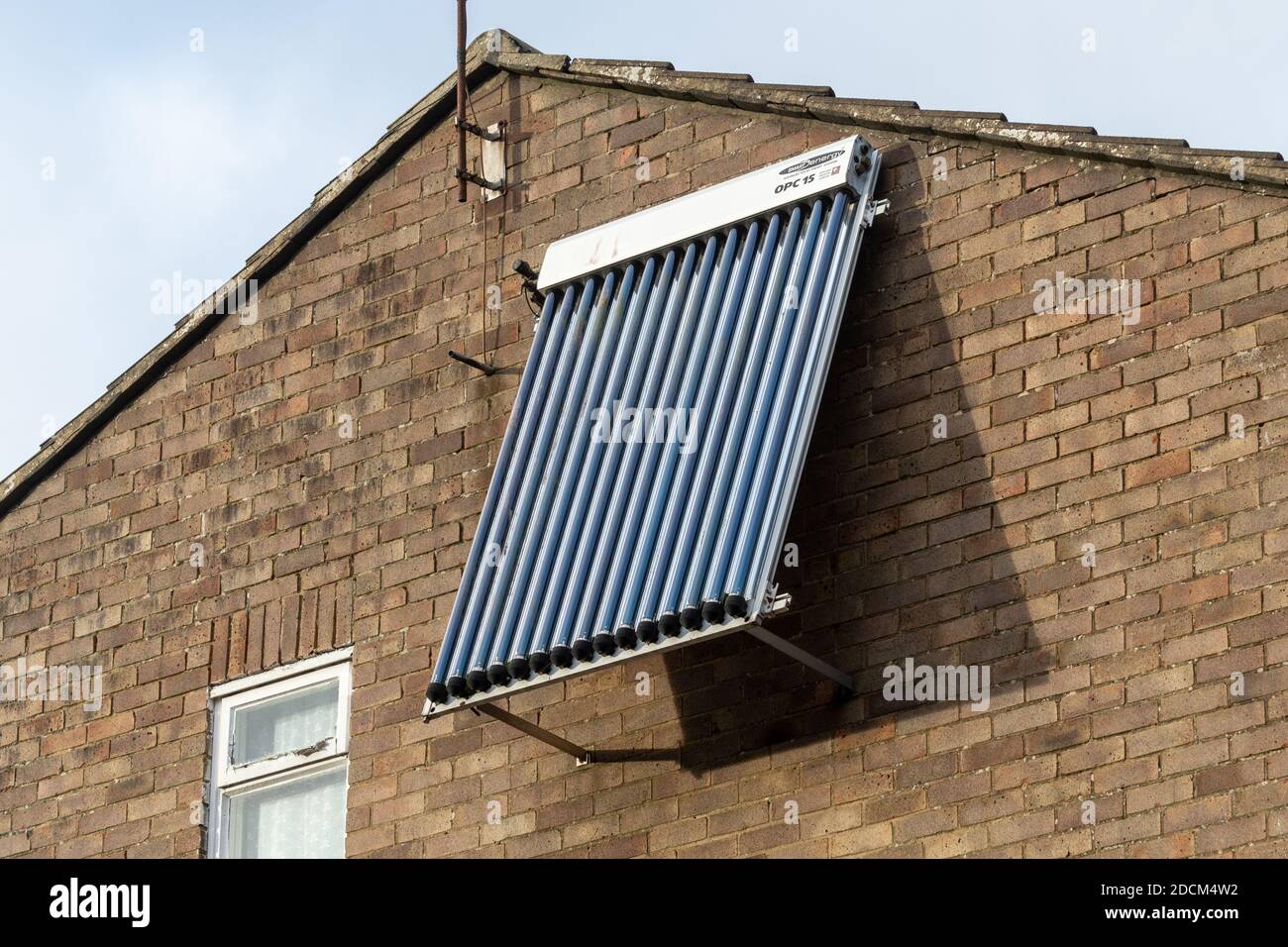 Ein solarthermisches Panel, evakuierte Röhre, OPC 15, montiert an der Wand eines Hauses, UK. Erneuerbare grüne nachhaltige Energie für das Haus. Stockfoto