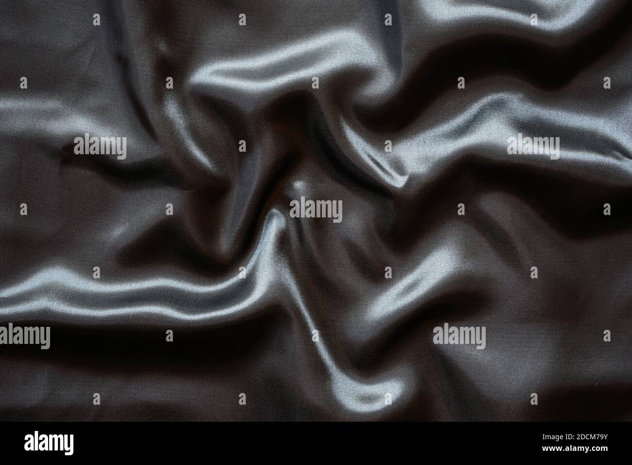Falten schwarzen Satin Tuch Textur Hintergrund Stockfoto