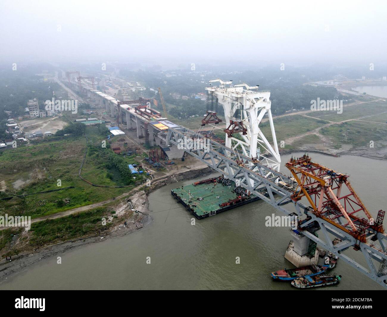 Munshiganj. November 2020. Eine Spannweite wird auf Säulen der Padma-Brücke auf der Baustelle am Stadtrand von Dhaka, Bangladesch, am 21. November 2020 installiert. Ingenieure der China Railway Major Bridge Engineering Group Co, Ltd. (MBEC) haben erfolgreich die 38. Spannweite der Padma-Brücke in Bangladesch installiert. Die 3,140-Tonnen-Spanne wurde am Samstag zwischen Säule-1 und Säule-2 platziert, erklärte Dewan MD Abdul Kader, Manager des Padma Mehrzweck-Brückenprojekts von der Bangladesh Bridge Authority, Xinhua am Sonntag. Quelle: Xinhua/Alamy Live News Stockfoto