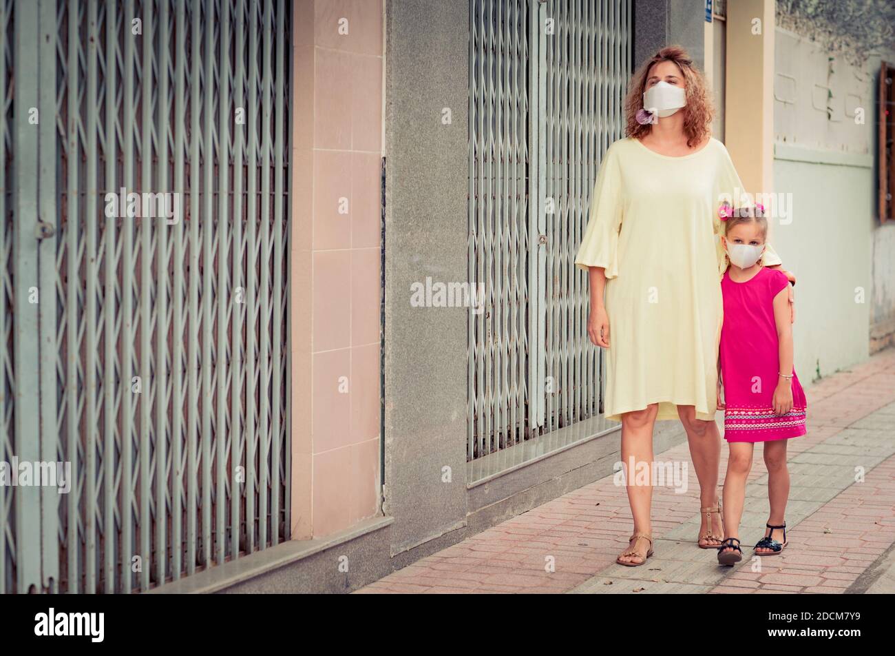 Frau und Tochter tragen eine Einwegmaske, um Virusinfektionen zu vermeiden. Schutz vor Coronavirus Stockfoto