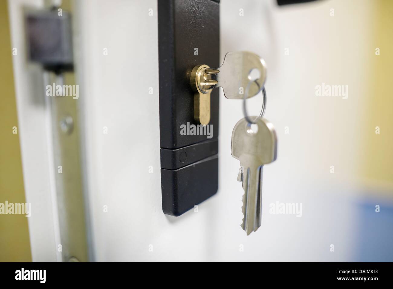Bild mit geringer Schärfentiefe (selektiver Fokus) mit Metalltasten in eine Türverriegelung. Stockfoto