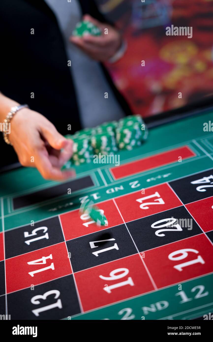 Frau spielt am Roulettetisch im Casino Stockfoto