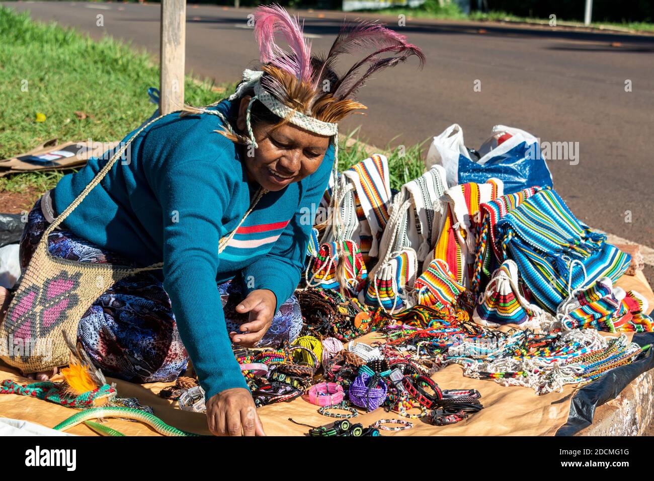 Eine Frau, die zur Gruppe der kulturell verwandten indigenen Völker Guaraní gehört und ihre handgefertigten Kunst und Kunsthandwerk neben einer Hauptstraße an Touristen verkauft, Stockfoto