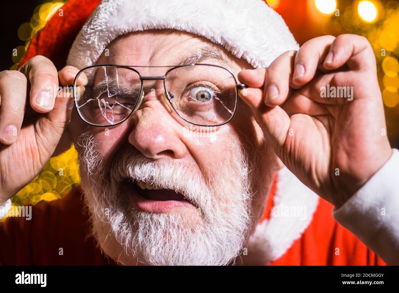 Weihnachtswerbung. Der Weihnachtsmann hält gebrochene Brillen. Weihnachtsmann mit zerbrochenen Gläsern. Der Weihnachtsmann hält eine gebrochene Brille. Weihnachtsmann. Anzeige Stockfoto