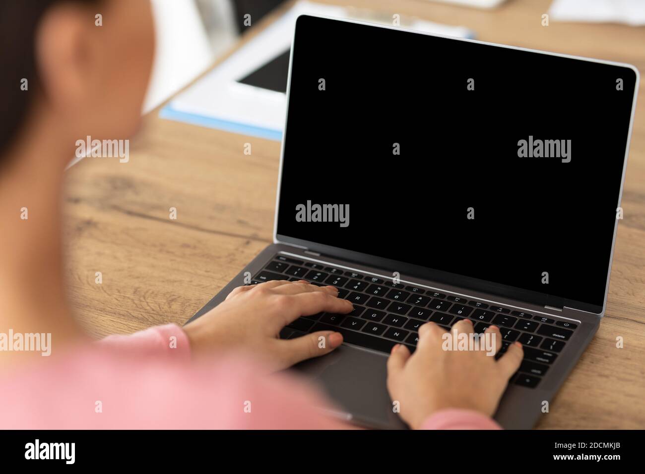 Lady arbeitet auf Laptop mit leeren schwarzen Bildschirm für mockup Stockfoto