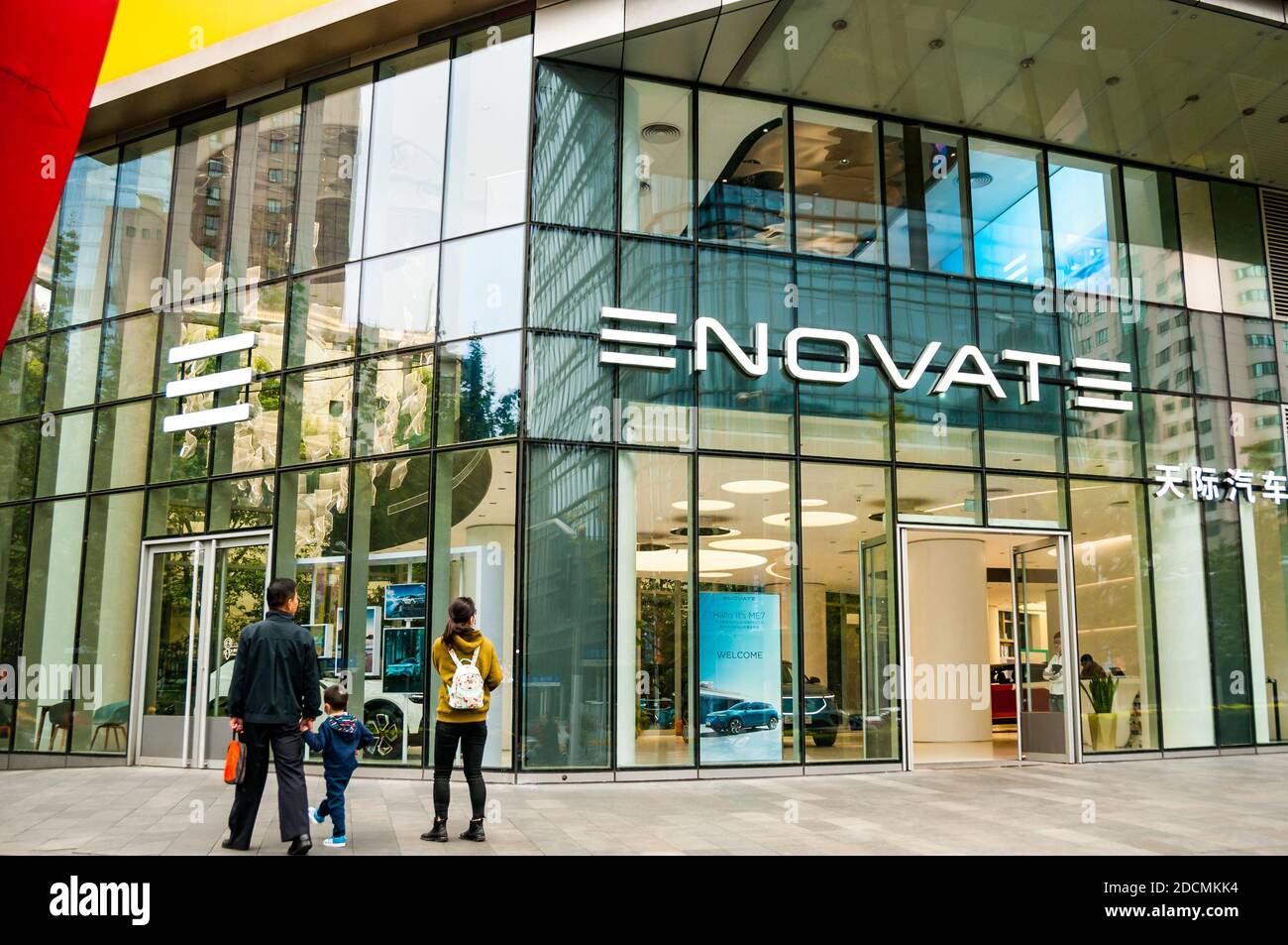 Ein Blick der Familie durch das Fenster auf die Elektroautos von Enovate in einem Showroom an der Changde Road im Jing’an District in Shanghai. Stockfoto