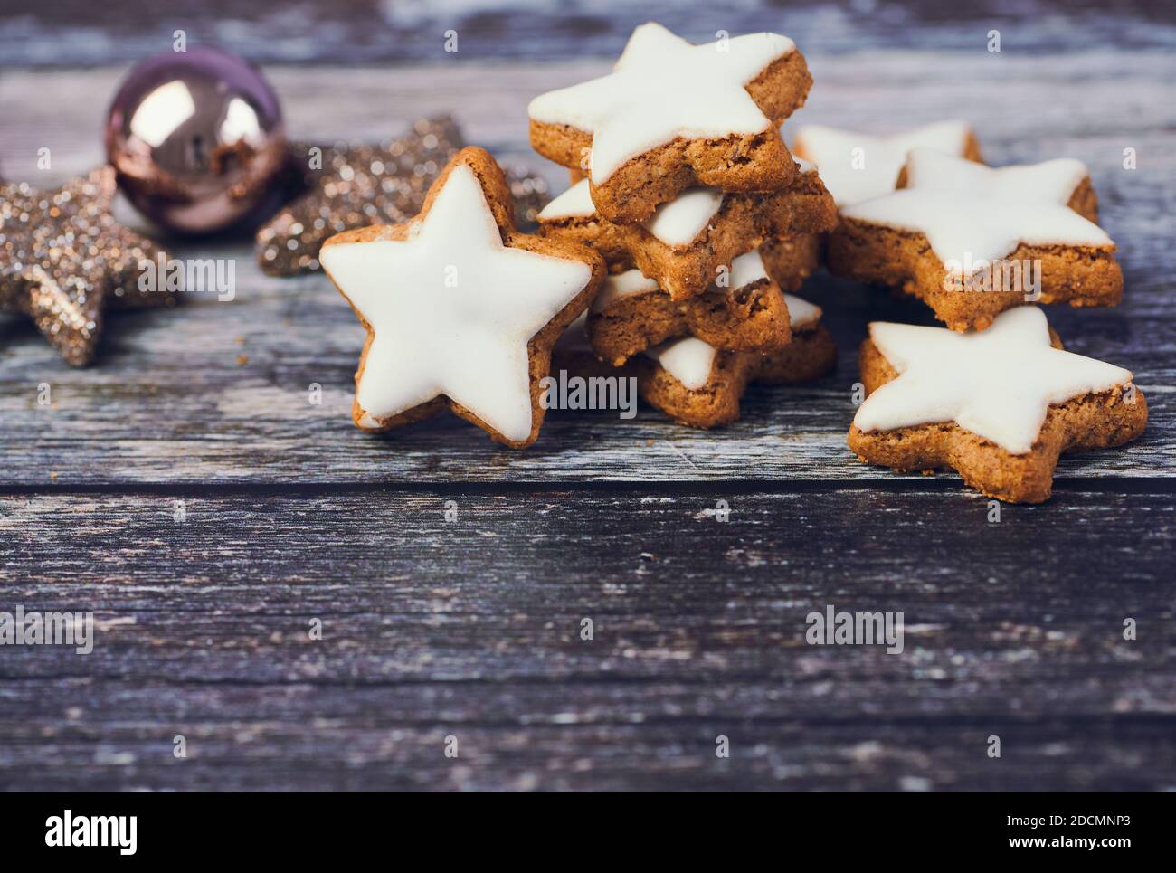 weihnachtshintergrund für Grußkarten mit Kopierraum, Zimt Sterne neben einem weihnachtsball auf Holzhintergrund Stockfoto