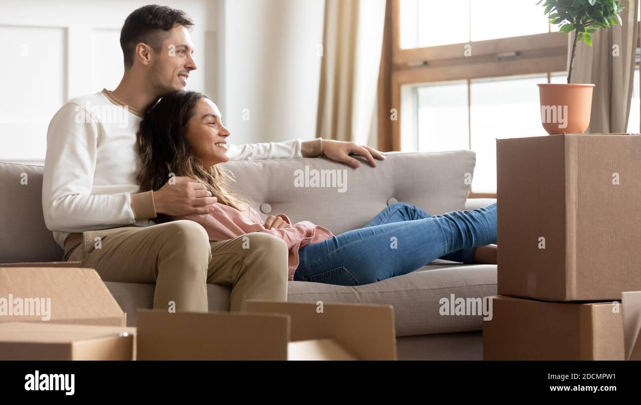 Paar, das sich am Tag auf der Couch ausruhte, um in ein neues Zuhause zu kommen Stockfoto