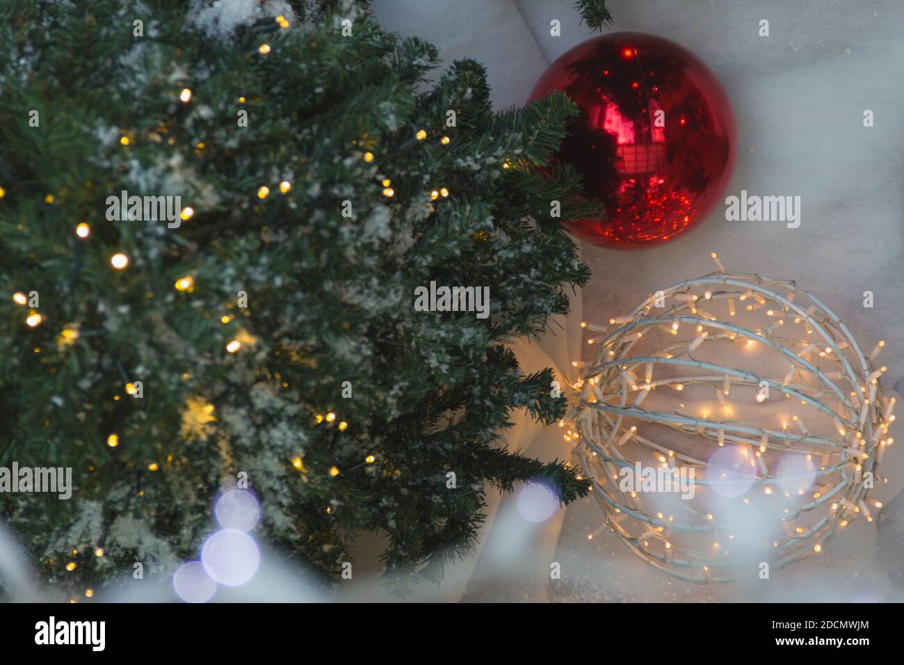 Blick von oben auf grünen Weihnachtsbaum, rote Kugel und Lichter Dekoration über gefälschte Schneeboden. Einkaufszentrum Winter Urlaub Dekoration Stockfoto