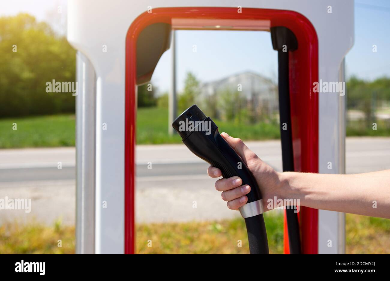 Ein Mann hält einen Ladestecker für ein Elektroauto Stockfoto