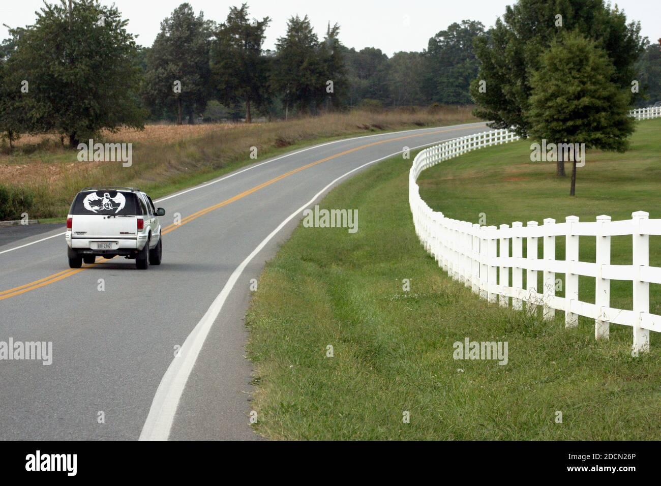 Landstraße in Virginia, USA. Ländliches Anwesen, das von einem langen Vinylzaun umgeben ist. Stockfoto