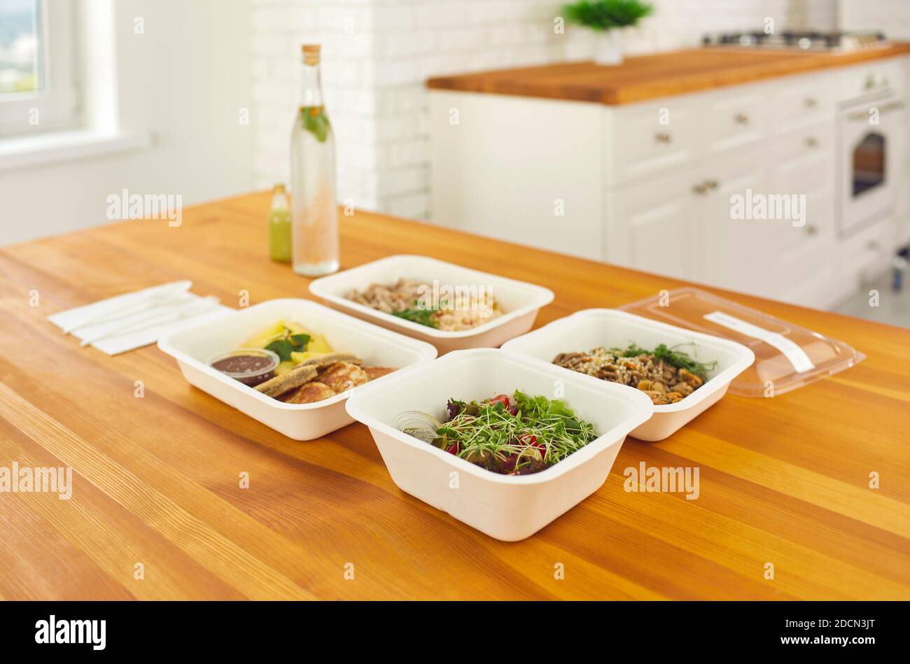 Auf dem Tisch vier Behälter mit bereit eine Vielzahl von gesunden Lebensmitteln in den Lieferservice bestellt. Stockfoto