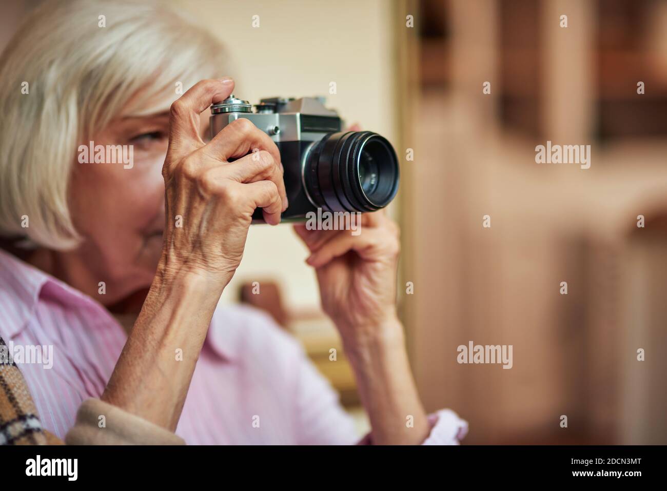 Nahaufnahme der grauhaarigen älteren Frau mit Kamera und gehen, um Foto zu machen. Lifestyle-Konzept. Speicherplatz kopieren Stockfoto