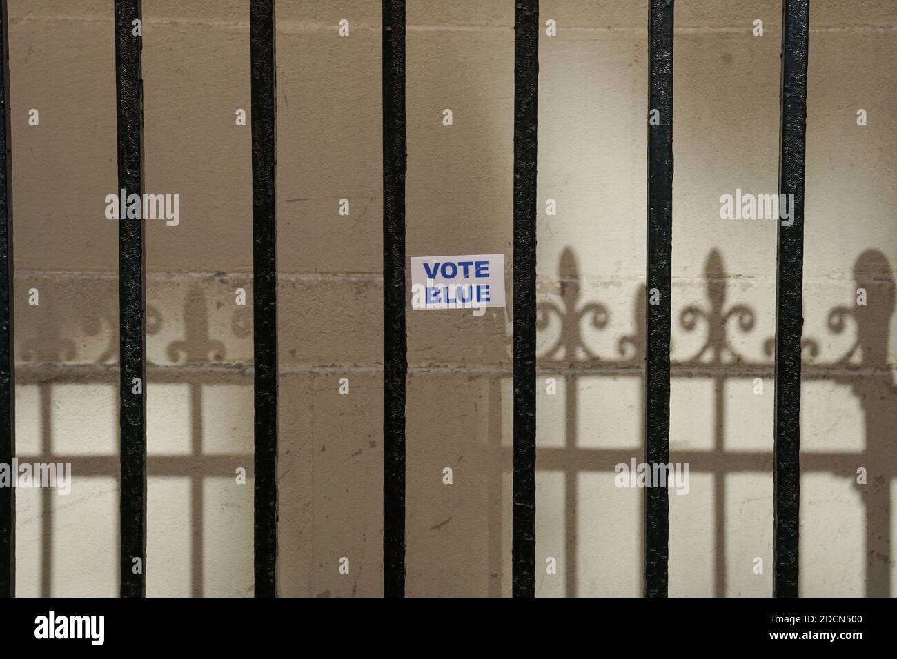 NEW YORK - 17. Oktober 2020: 'Vote Blue' Aufkleber an der Wand durch ein Tor geschossen. Stockfoto