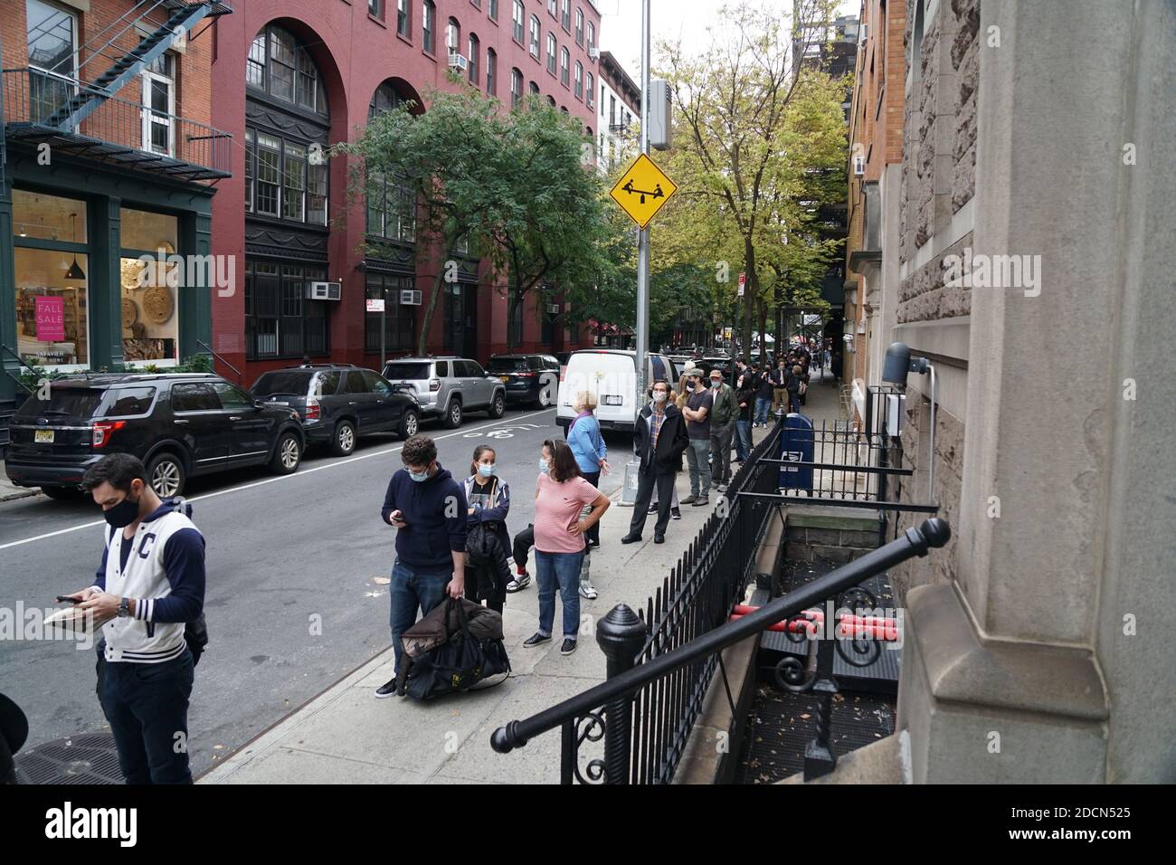 NEW YORK - 24. Oktober 2020: 1. Tag der frühen Abstimmung in NYC. Leute lesen während sie online warten, also Ho. Stockfoto