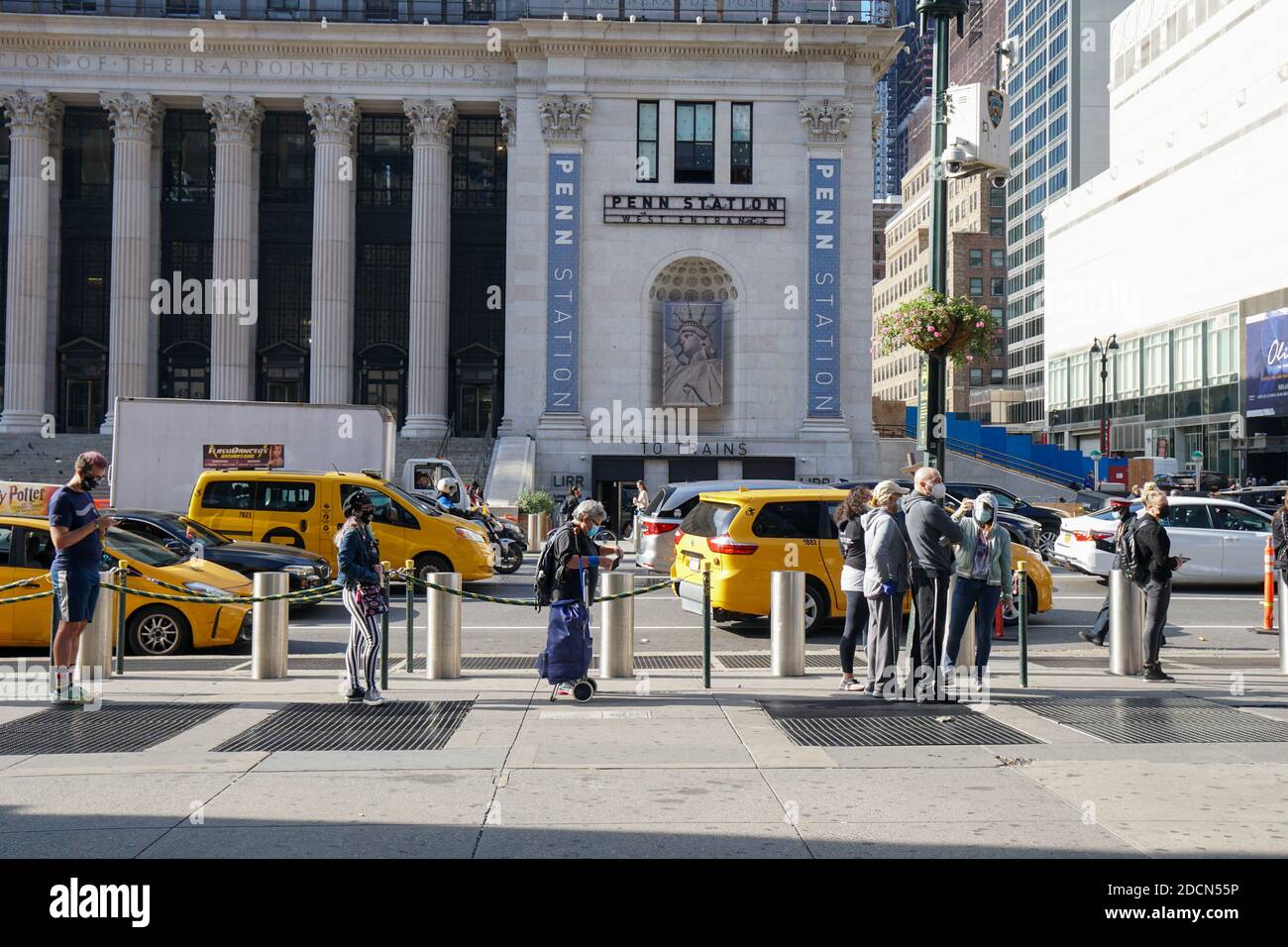 NEW YORK - 24. Oktober 2020: Die Leute warten am Madison Square Garden auf den ersten Tag der frühen Abstimmung. Blick vom 8. Ave entlang des Taxistandes. Stockfoto