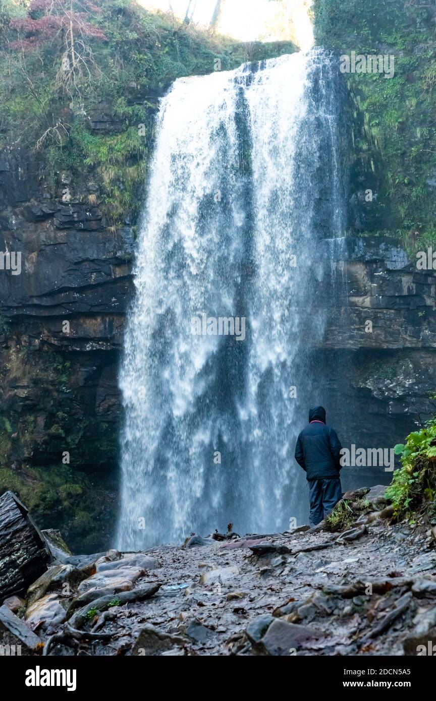 Männchen mittleren Alters stand vor den Henrhyd Falls in der Nähe von Coelbren, dem höchsten Wasserfall in South Wales, Großbritannien Stockfoto