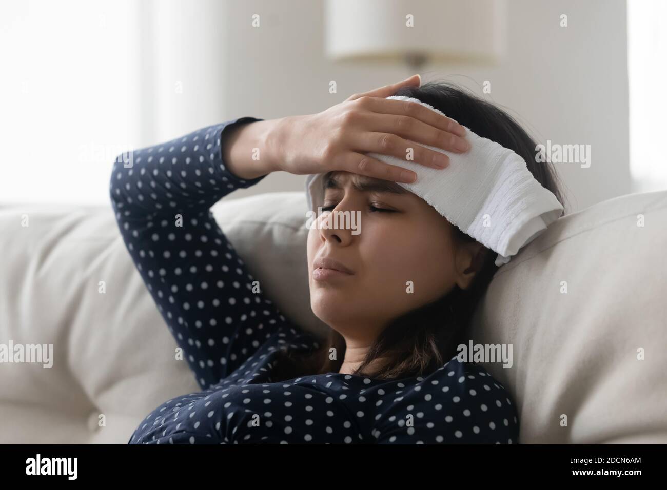 Nahaufnahme ungesunde asiatische Frau hält nasses Handtuch auf der Stirn Stockfoto